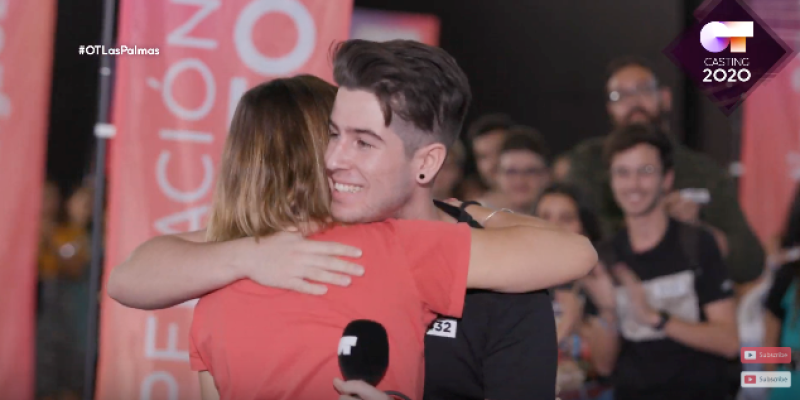 Un aspirante abraza a Noemí después de recibir pegatina