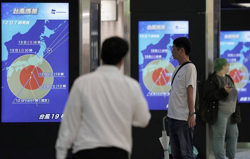 Varias personas observan paneles con información sobre el tifón Hagibis en la estación de tren de Tokio. Las autoridades japonesas han dado órdenes de evacuación para cientos de miles de personas.