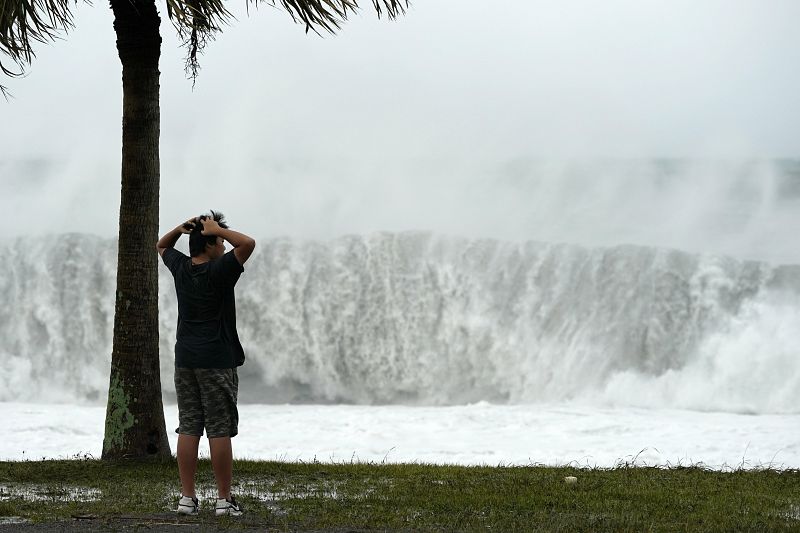 Un joven observa las enormes olas que ha provocado el tifón Hagibis en Atawa.