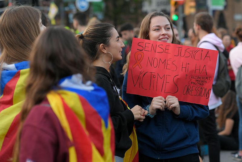 Un manifestante sostiene un cartel que dice en Catalán "Sin justicia solo hay víctimas".