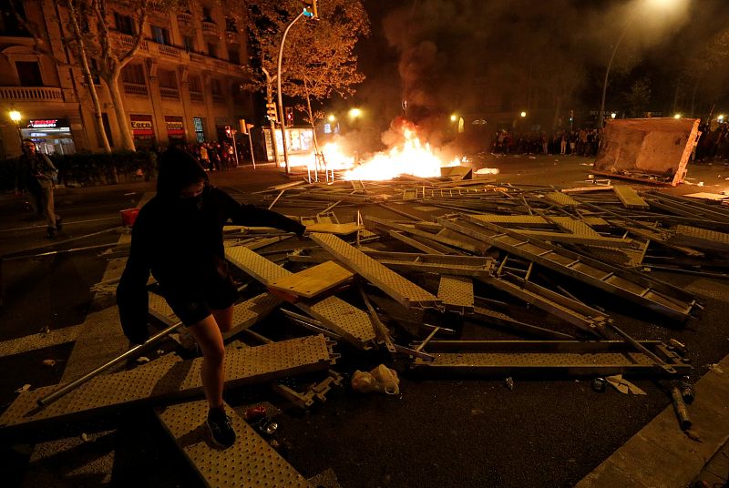 Un manifestante camina sobre una barricada durante el tercer día de protestas en contra de la sentencia del 'procés'.