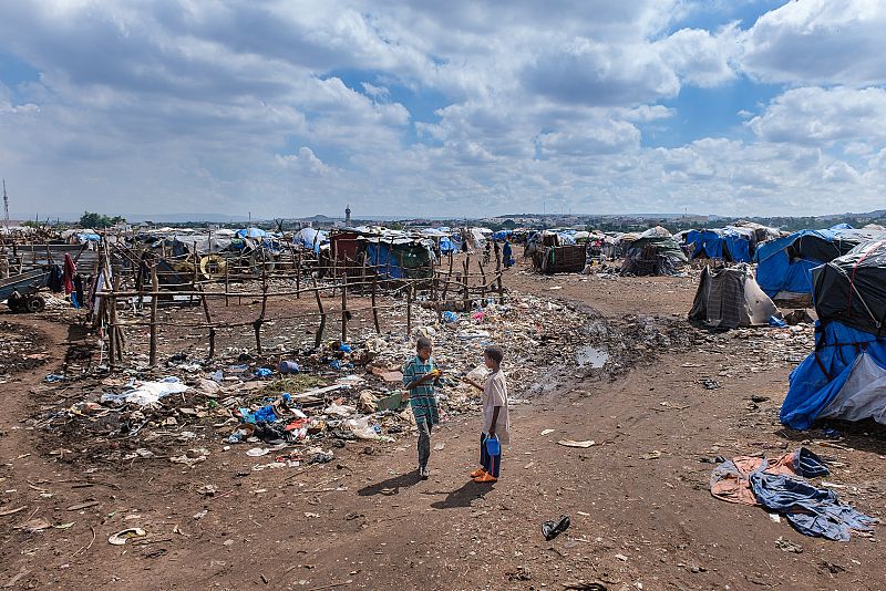 Un corral para animales y viviendas construidas entre la basura en Faladie