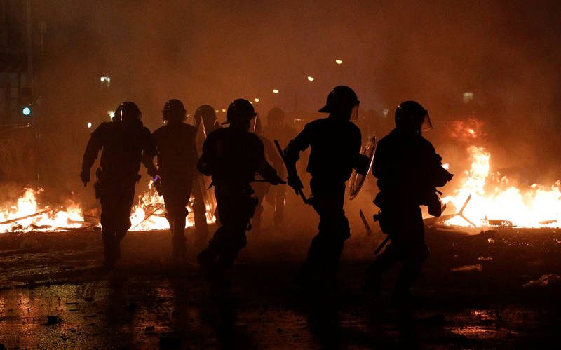 La policía antidisturbios camina ahcía una barricada durante los actos de protesta en Barcelona. 
