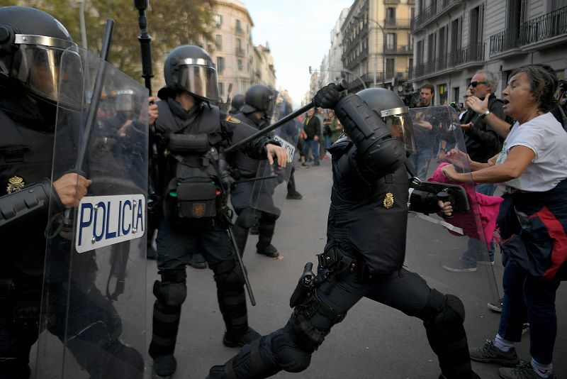 Un policía golpea a un manifestante durante la manifestación convocada por los CDR.