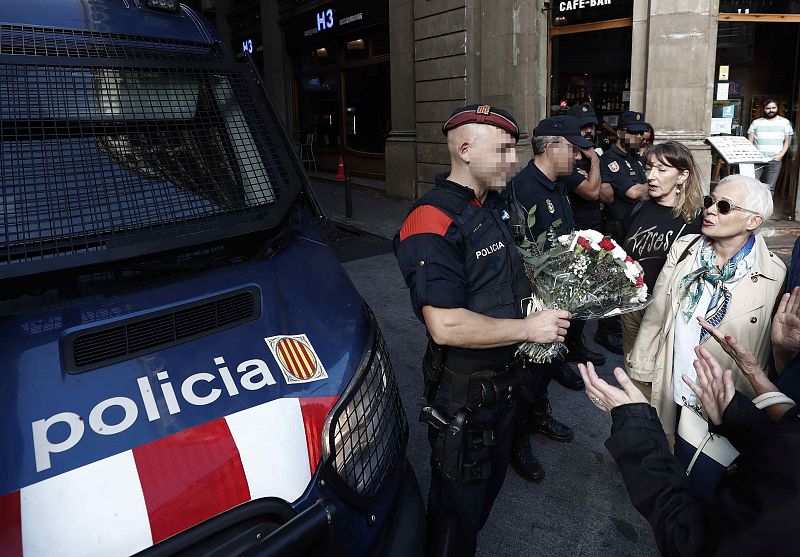 Varias personas entregan obsequios a los policias nacionales y mossos d'esquadra, en la Vía Laietana de Barcelona, tras los incidentes ocurridos en los últimos días.