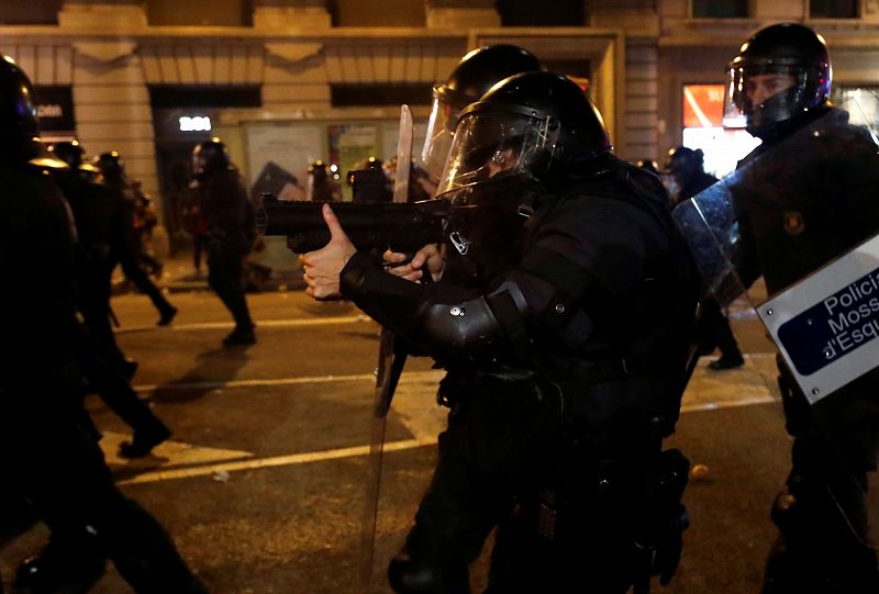 Un agente utiliza su escopeta de balas de goma para hacer frente a los manifestantes convocados por los CDR.