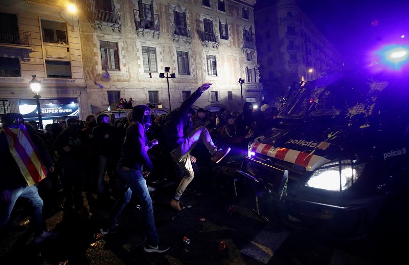 Un manifestante radical golpea uno de los furgones de los Mossos desplazados a Vía Laietana.