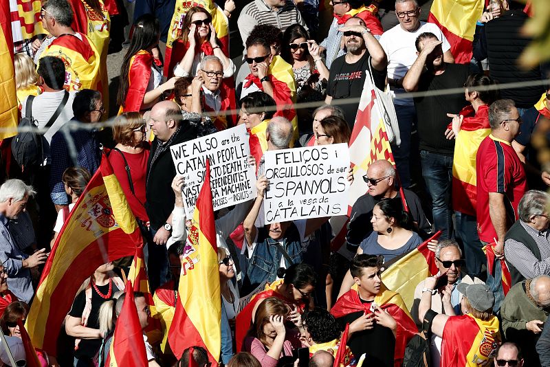 Manifestantes con carteles donde se lee "Felices y orgullosos de ser españoles y catalanes"