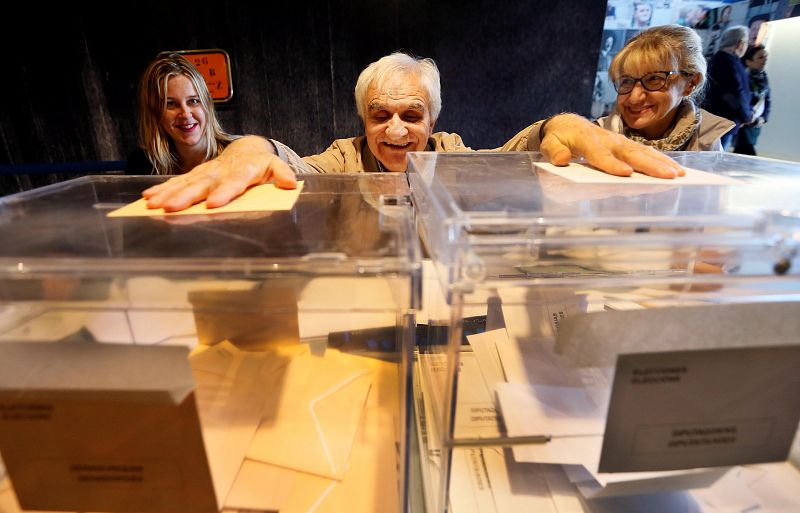 El invidente César Puente Fuente preside una mesa electoral en la ciudad de Alicante con la ayuda de una amiga que le facilita la identificación de cada votante.