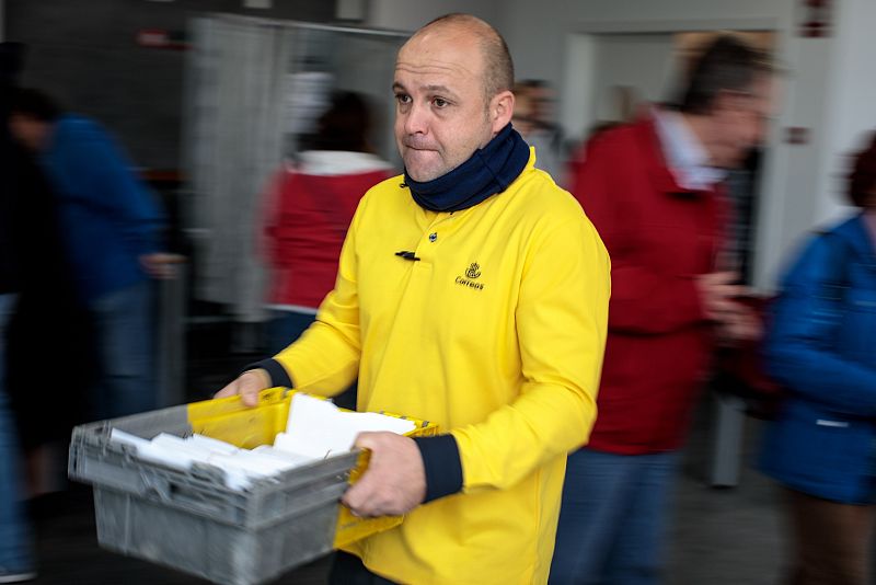 Un trabajador de correos reparte el voto por correo en un colegio electoral de Valencia. 