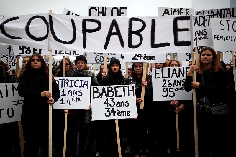 Mujeres portan pancartas con el nombre y la edad de víctimas de violencia de género