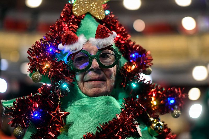 Una mujer vestida de árbol de Navidad asiste al sorteo de la Lotería de Navidad, en el Teatro Real de Madrid.