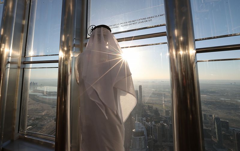 Un hombre observa un eclipse solar parcial desde el piso 124 del Burj Khalifa, el edificio más alto del mundo, en Dubai, Emiratos Árabes Unidos.