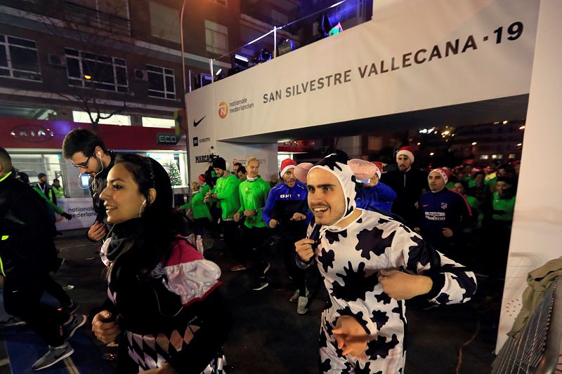 Un corredor disfrazado de vaca toma la salida de la San Silvestre Vallecana 2019.