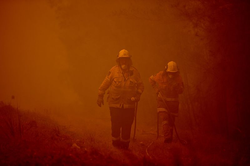 Dos bomberos trabajan en la extinción de un fuego en Moruya