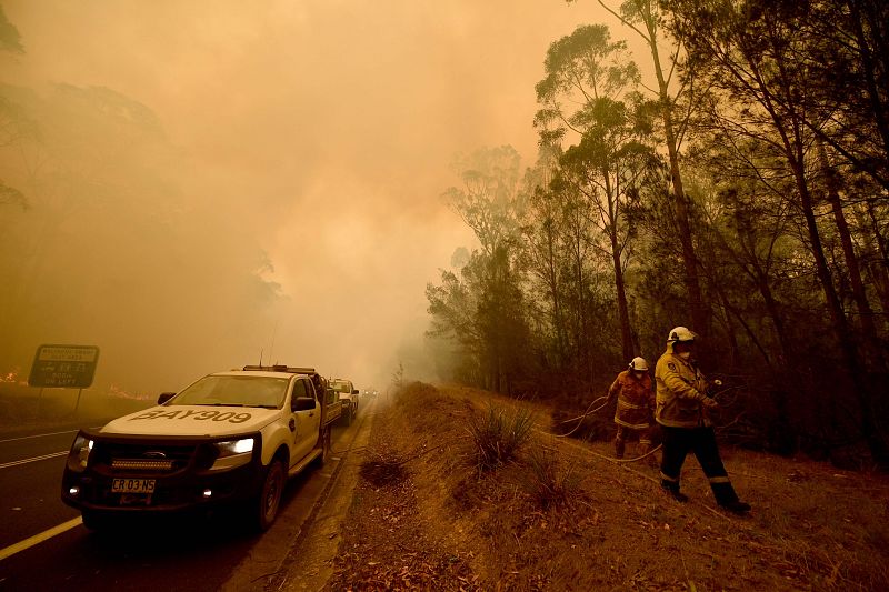 Los bomberos trabajan en las tareas de extinción de un incendio en la ciudad de Moruya