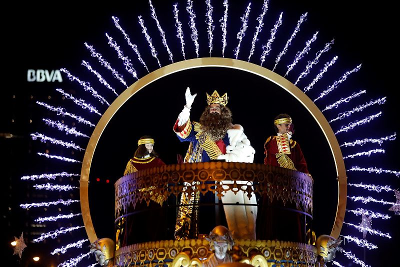 El rey Gaspar saluda desde su carroza durante la tradicional cabalgata