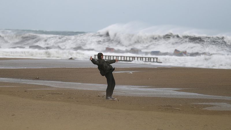 Un hombre se resiste a la fuerza del viento en la Barceloneta