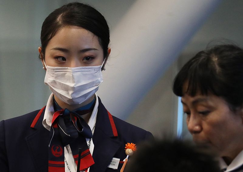 Una trabajadora de Japan Airlines utiliza una mascarilla protectora en el aeropuerto internacional de Los Ángeles.