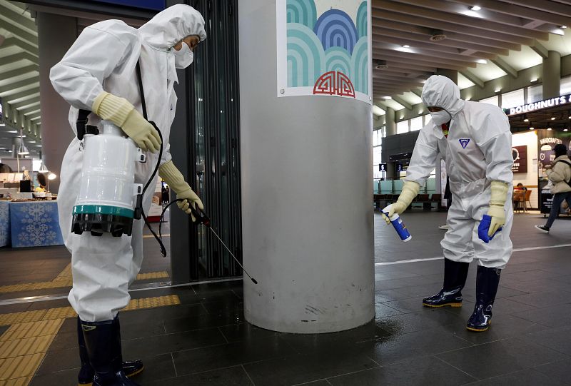 Trabajadores de limpieza desinfectan la estación de Suseo en Seúl.