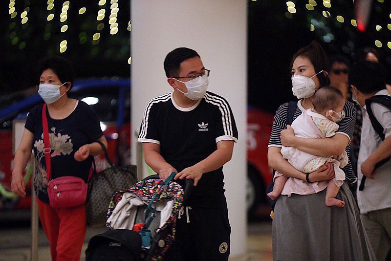 Una familia con mascarillas protectoras ante la propagación del virus que ya se ha cobrado la vida de 25 personas.