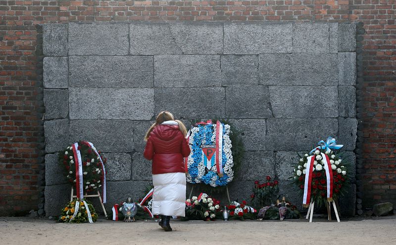 Flores y coronas en el 'muro de la muerte' de Auschwitz