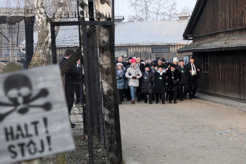 El presidente de Polonia, Andrzej Duda, y el director del Museo Memorial de Auschwitz-Birkenau, Piotr Cywinski, entran tras varios sobreivientes y sus familiares para el acto conmemorativo.