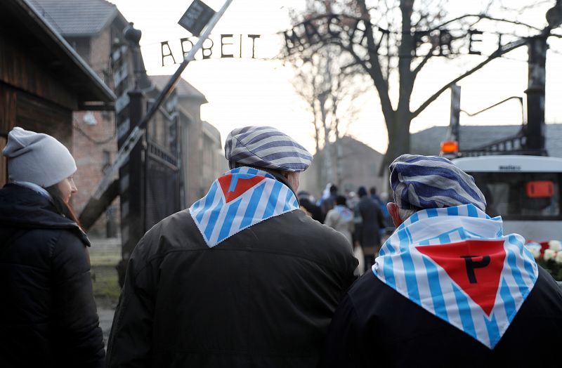 Un grupo de supervivientes accede al Museo Memorial de Auschwitz por la 'puerta de la muerte' del campo principal