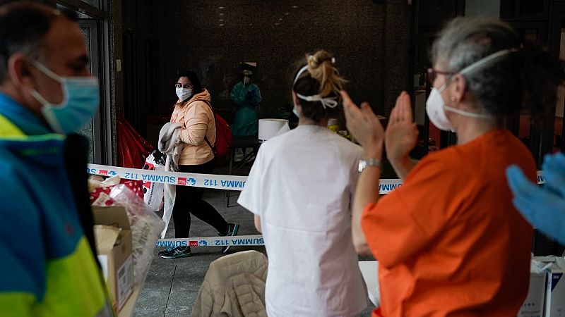 Un grupo de sanitarios se despiden de un paciente que ha recibido el alta en el hospital instalado en Ifema.