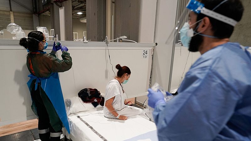 Dos sanitarios atienden a una paciente con coronavirus, del que ya hay 94.417 contagios en España.