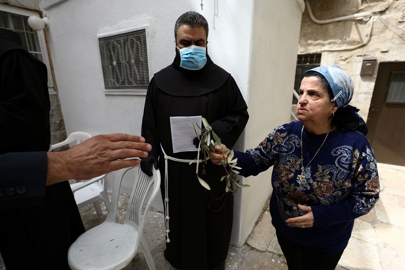 Miembros del Patriarcado Latino de Jerusalén distribuyen ramas de olivo a los fieles confinados en sus casas por el coronavirus.