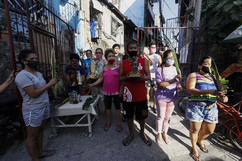 Fieles católicos en Ciudad Quezón (Filipinas) se protegen con máscaras en este Domingo de Ramos.