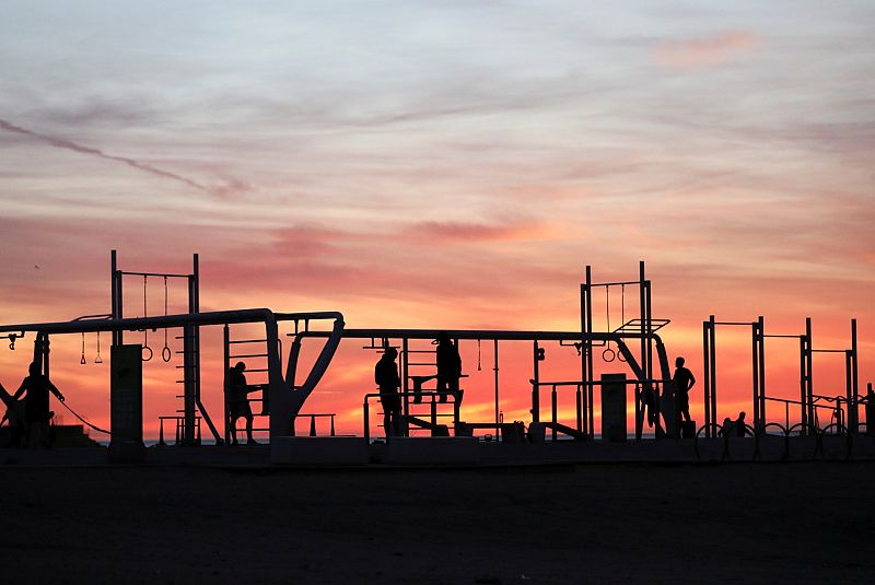 Un grupo de personas hacen ejercicio en la playa de la Barceloneta durante las horas en que se permite el ejercicio individual al aire libre.