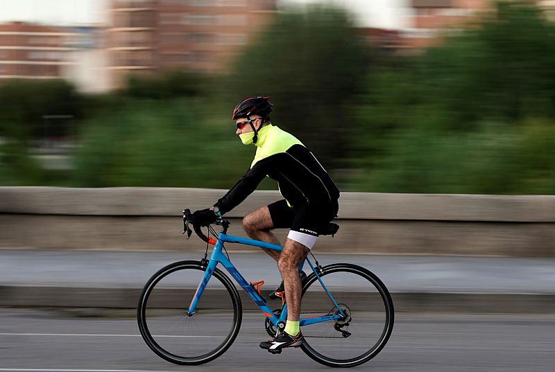 Un hombre monta en bicicleta por Madrid Río durante las horas permitidas para el ejercicio individual.