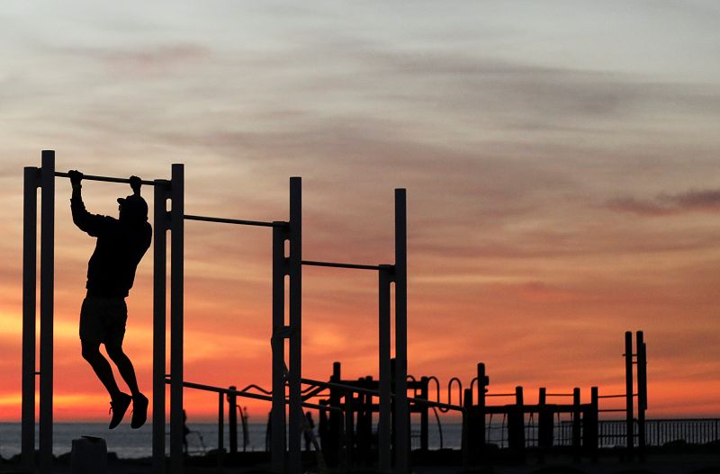 Un hombre hace deporte en la playa de la Barceloneta, por primera vez durante la epidemia.