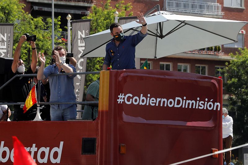 El líder de Vox, Santiago Abascal (d), en un autobús durante la manifestación en coche en Madrid.