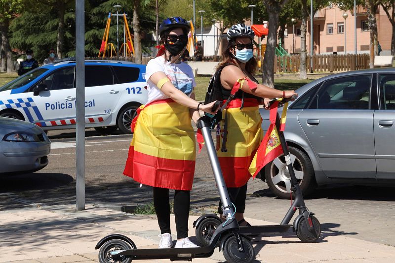 Dos ciudadanas se unen en patinete a las protestas promovidas por Vox en Salamanca.