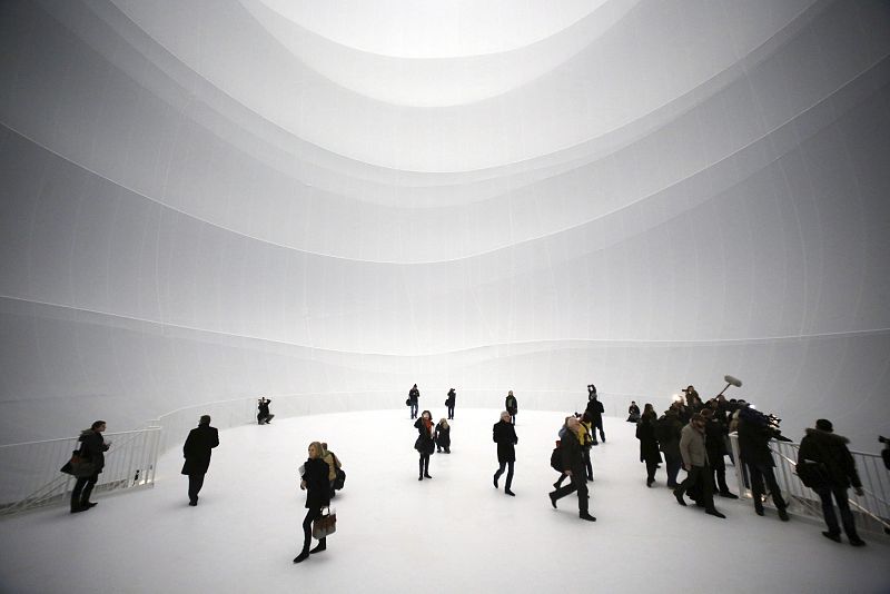 Varias personas disfrutan de la obra en Gasometer de Oberhausen, Alemania. La obra elaborada con paredes transparentes de 90 metros.