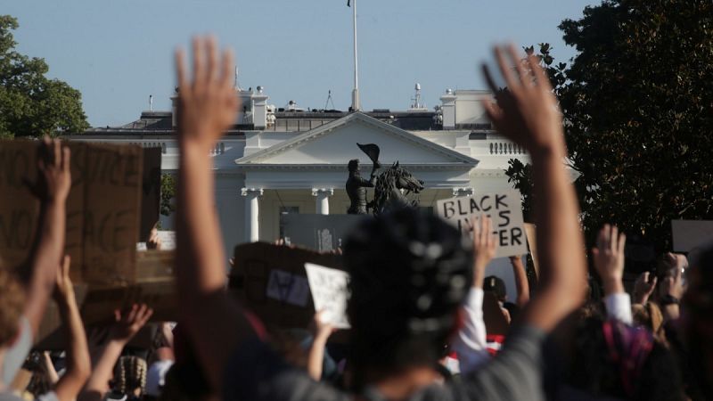 Cientos de manifestantes alzan los brazos en protestas de la muerte de George Floyd en Minneápolis.