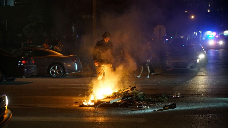 Un manifestante se encuentra ante un incendio en la calle durante una protesta contra la muerte de George Floyd a manos de una agente.