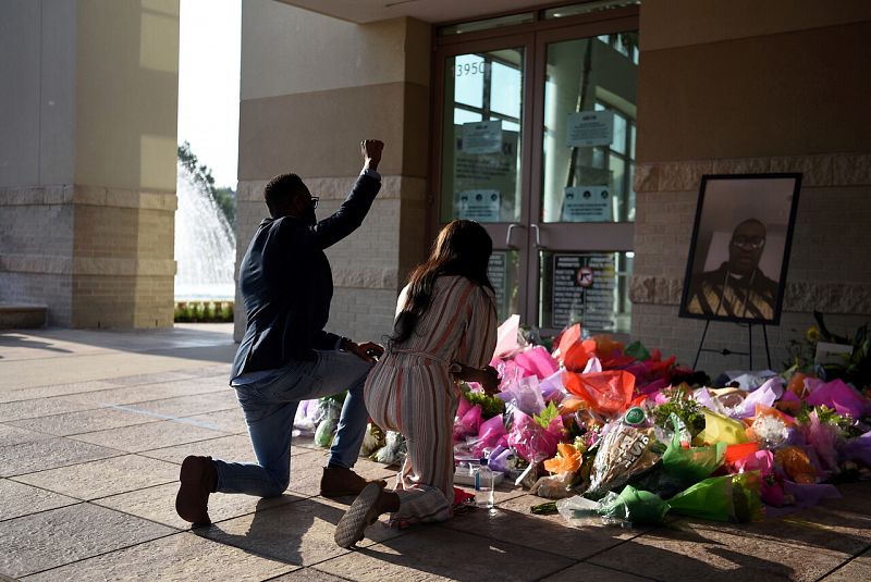 Una pareja rse arrodilla para rendir homenaje a Floyd