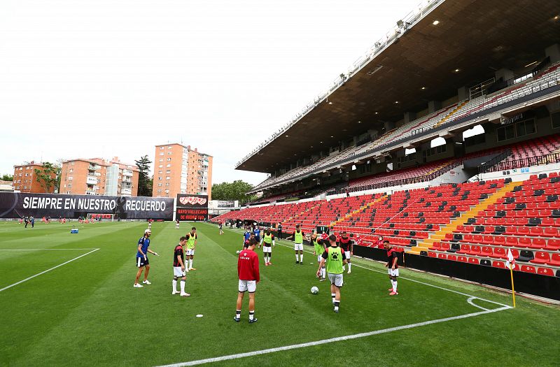 Los jugadores calientan en el estadio vacío antes del comienzo de los 45 minutos aplazados.