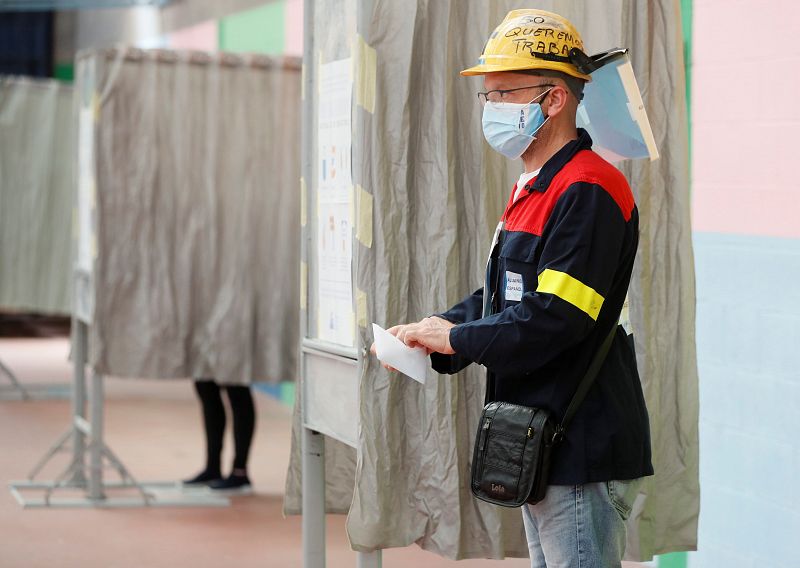 Un trabajador de ALCOA sale de la cabina tras votar en un colegio electoral de Burela (Lugo), este domingo con motivo de las elecciones autonómicas.