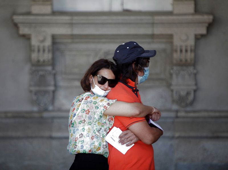 Dos personas aguardan en la fila para votar, este domingo en un colegio electoral de A Coruña con motivo de las elecciones autonómicas.