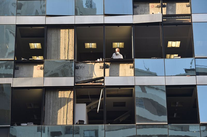 Un hombre mira por la ventana el día después de la explosión