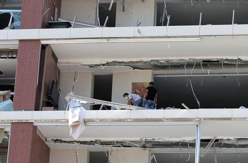 Dos hombres inspeccionan los daños un día después de la explosión