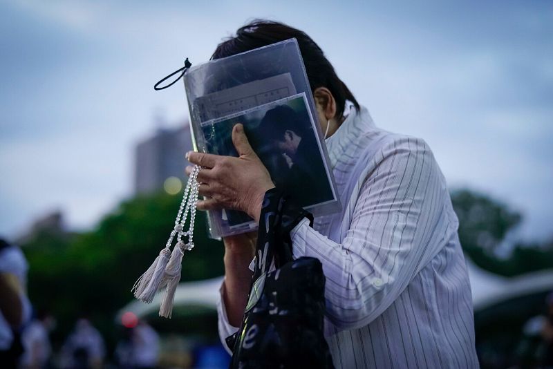 Una mujer se aferra a la foto de uno de sus familiares víctima del bombardeo durante el minuto de silencio en el 75 aniversario de recuerdo por los fallecidos.