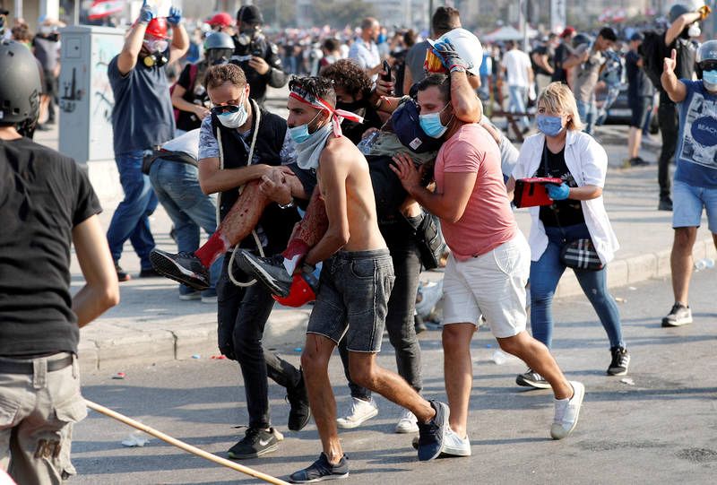 Varios manifestantes cargan con un herido en las protestas