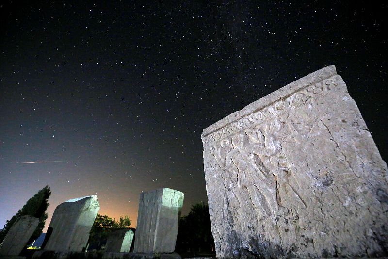 Un meteoro atraviesa las estrellas en el cielo nocturno sobre las lápidas medievales durante la lluvia de meteoros Perseidas en Radimlja cerca de Stolac, Bosnia y Herzegovina.