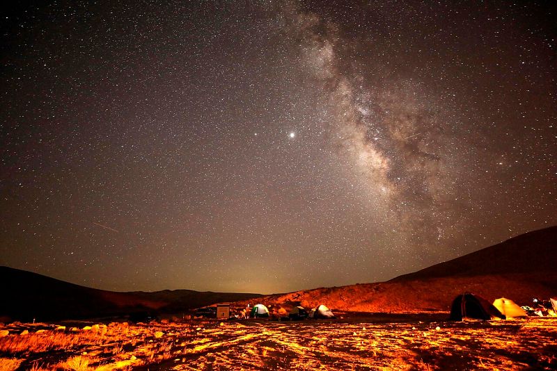 Un meteoro de las Perseidas cruza el cielo sobre un campamento en el desierto de Negev cerca de la ciudad de Mitzpe Ramon, en Israel.